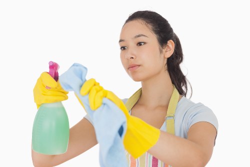 Dusting and sanitising high-touch areas in an Ilford office